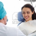 12324958-jeune-femme-assise-dans-un-fauteuil-dentaire-et-en-regardant-un-medecin
